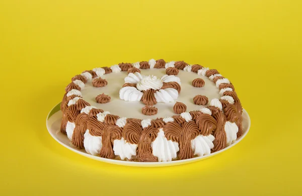 Bir tabak üzerinde sarı bir arka plan üzerinde harika kek — Stok fotoğraf