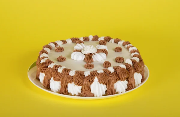 Wonderful gateau on a dish on a yellow background — Stock Photo, Image