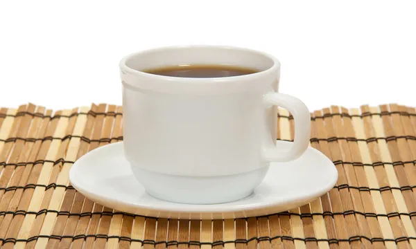 Tazza di caffè e piattino su un tovagliolo di bambù, su bianco — Foto Stock