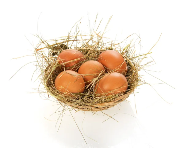 Eggs, hay in a bast basket, isolated on white — Stock Photo, Image