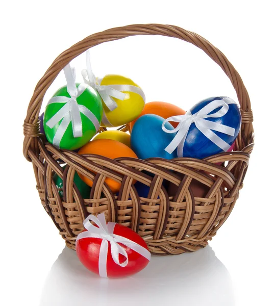 The color eggs decorated with ribbons, in the wattled basket, isolated on white — Stock Photo, Image