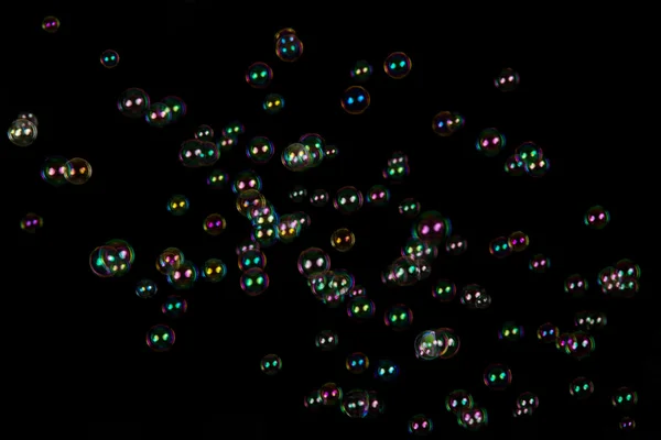 Las burbujas de jabón transparentes e iridiscentes aisladas en negro — Foto de Stock