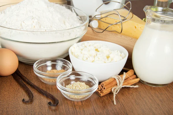 Jug with milk, cottage cheese, a flour, egg and spices, on a table — Stock Photo, Image