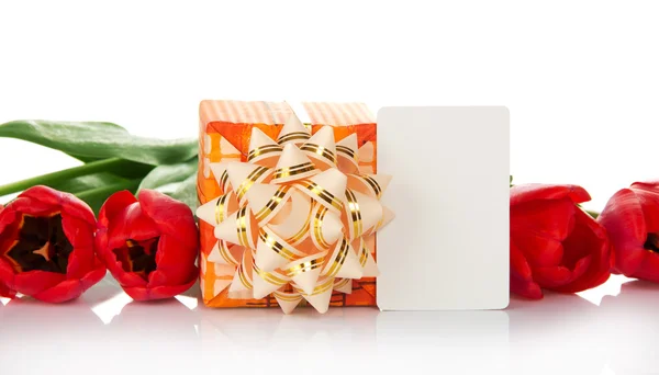 Яркая подарочная коробка с луком, тюльпанами и пустой карточкой для текста, изолированная на белом — стоковое фото
