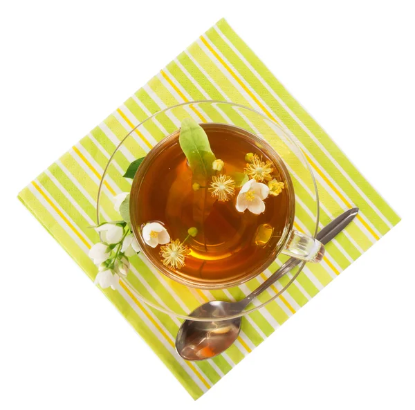 Flower τσάι σε ένα φλιτζάνι με ένα κουτάλι, ένα πιατάκι, μια πετσέτα που απομονώνονται σε λευκό — Φωτογραφία Αρχείου