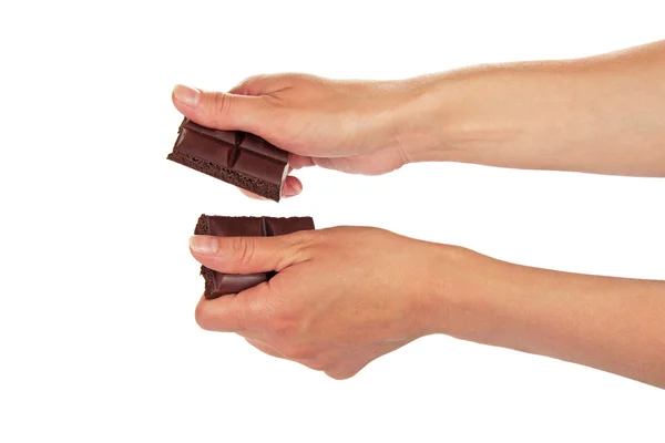 Vrouwelijke handen breken een tegel van de zwarte chocolade, geïsoleerd op wit — Stockfoto