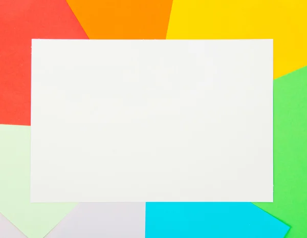 Tarjeta blanca en hojas de papel a color. Contexto — Foto de Stock