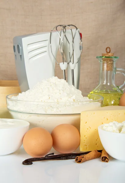 Eier, Mehl, Gewürze und ein Mixer gegen eine beige Leinwand — Stockfoto