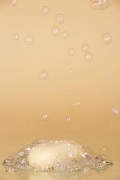 Pieza de jabón de tocador y jabones con burbujas de aire textura, sobre un fondo beige —  Fotos de Stock