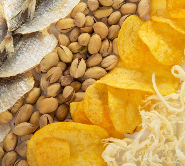 Chips, Tintenfische, Pistazien und salziger Fisch zu Bier — Stockfoto