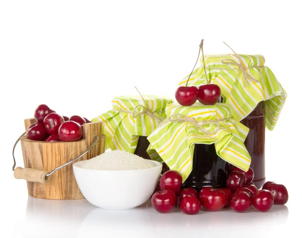 Jars of jam, cup with sugar, a wooden bucket with sweet cherries — Stock Photo, Image