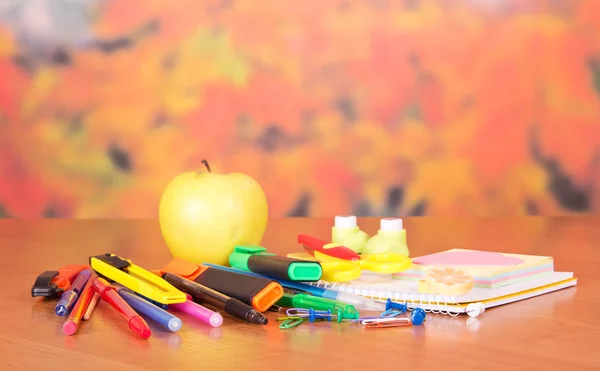 De vuelta a la escuela. El juego de los accesorios escolares, y la manzana, sobre la mesa —  Fotos de Stock