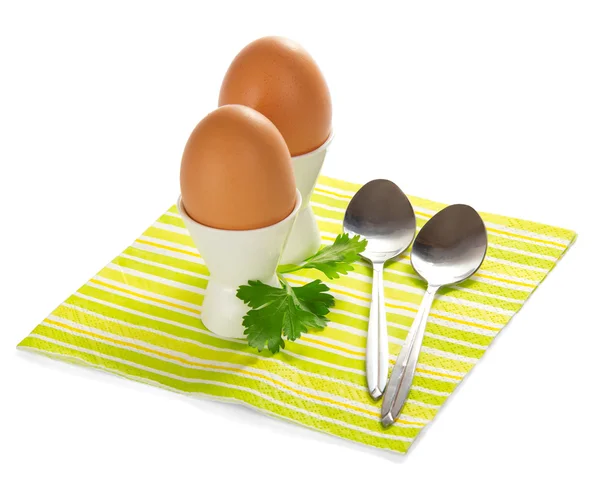 На полосатой салфетке из яиц, чайных ложек и петрушки, изолированной на белом — стоковое фото