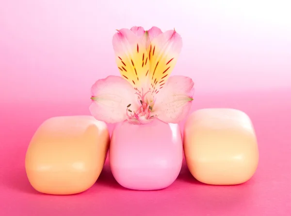 Sapone da toletta fragrante e il fiore su uno sfondo rosa — Foto Stock