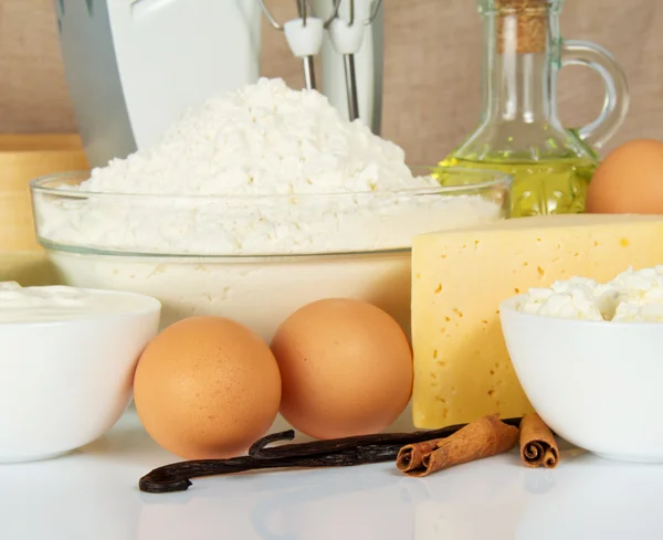 Cottage cheese, cheese, flour, sunflower oil and mixer on the beige — Stock Photo, Image