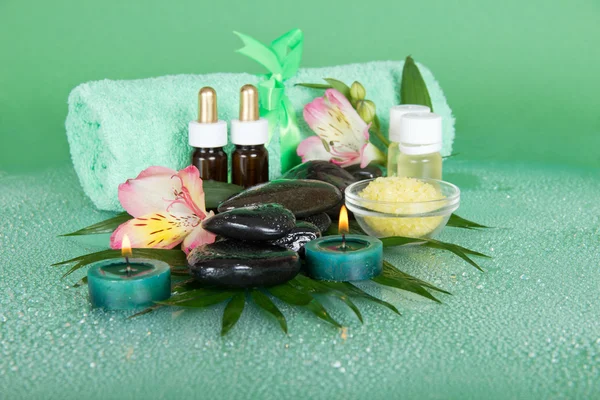 Set pour une aromathérapie, des bougies et une serviette éponge avec un noeud, sur fond vert — Photo