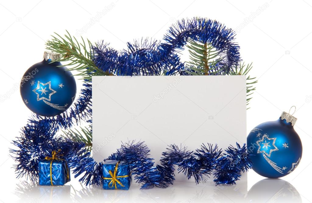 Fir-tree branch with tinsel, small gift boxes, two Christmas toy and a card isolated on white