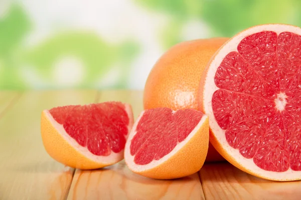 Segmentos de pomelo sobre una mesa de madera —  Fotos de Stock