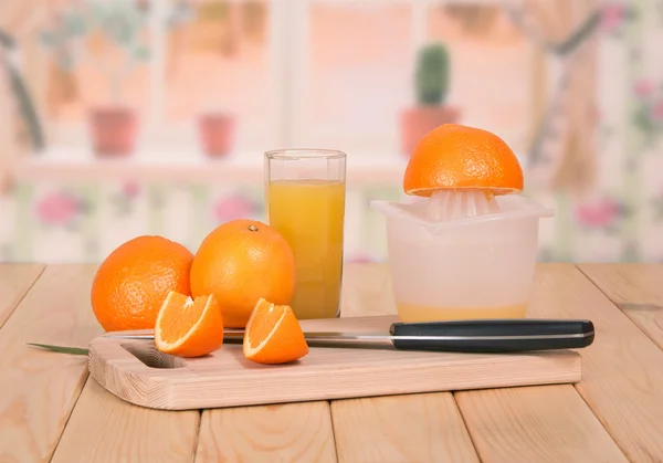 Knife, segments of orange and a juice glass — Stock Photo, Image