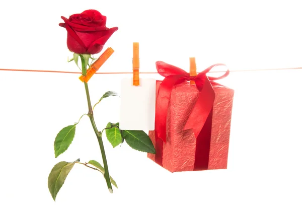 La rosa, la tarjeta y el regalo cuelgan de una cuerda de lino — Foto de Stock