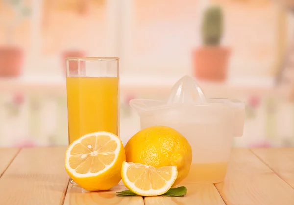 Cut lemon, juice extractor and glass — Stock Photo, Image