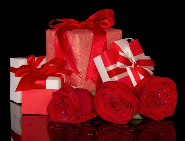 Розовый цветок и подарочные коробки изолированы на черный — стоковое фото