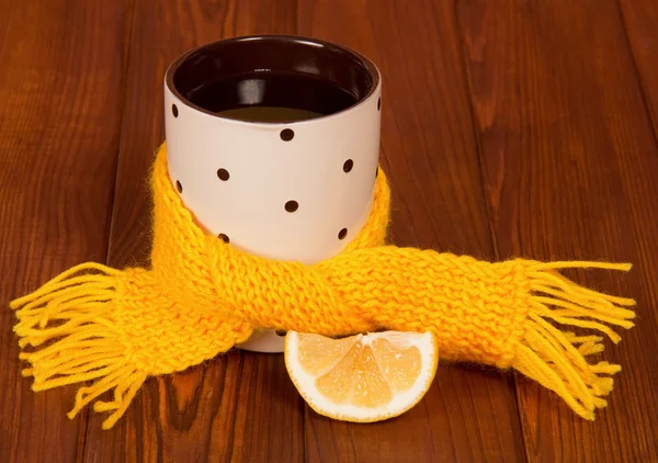 Aufguss von heißem Tee mit Zitrone in gelben Schal gewickelt — Stockfoto