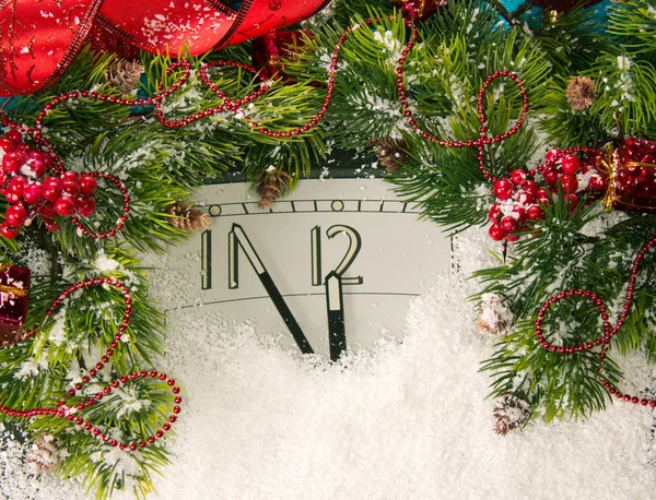 New Years clock and fir branches covered with snow — Stock Photo, Image