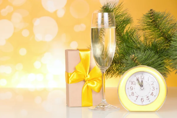 Christmas-tree branch, a glass of champagne, gift box and about twelve hours — Stock Photo, Image