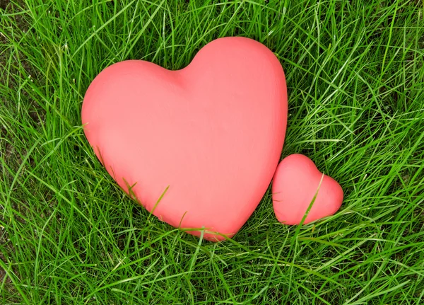 Corações vermelhos na grama verde — Fotografia de Stock