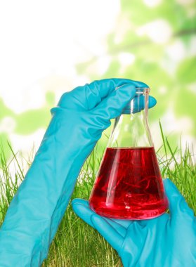 bir şişe sıvı ile elini tutar