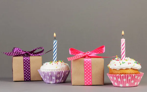 Cupcakes with candles and gift boxes — Stock Photo, Image