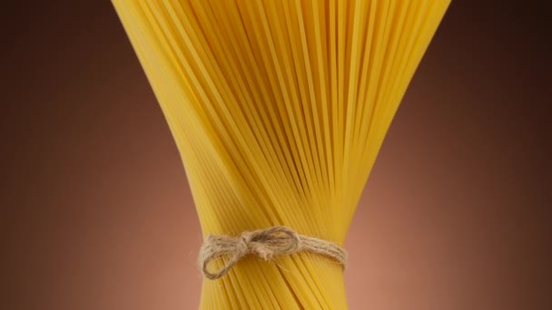 Pravé italské špagety těstoviny na hnědém pozadí, otočit. Veganské, vegetariánské jídlo