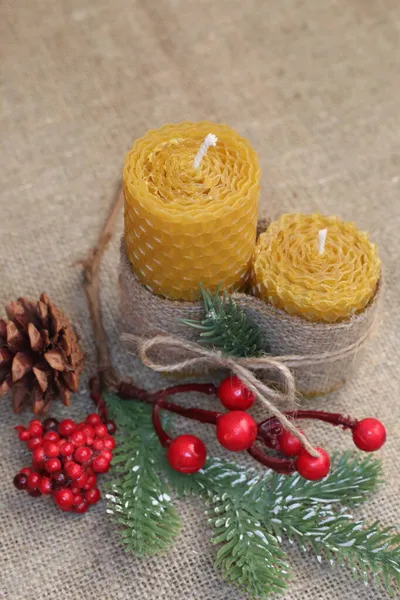 Handmade beeswax candles on the rustic background. Two natural bio wax candles as a decoration for home interior.