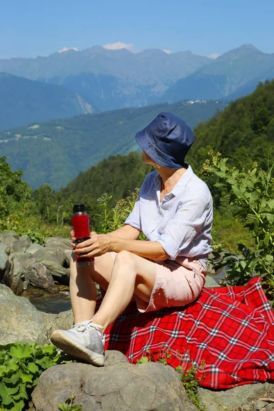 山に座って景色を楽しむ幸せな成熟した女性 — ストック写真