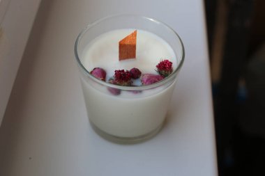 Beyaz zemin üzerinde ahşap fitili olan el yapımı soya mumu..