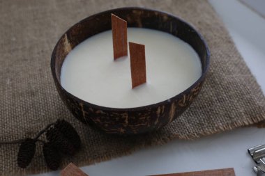 Beyaz arka planda hindistan cevizi kabuklu el yapımı soya mumu..