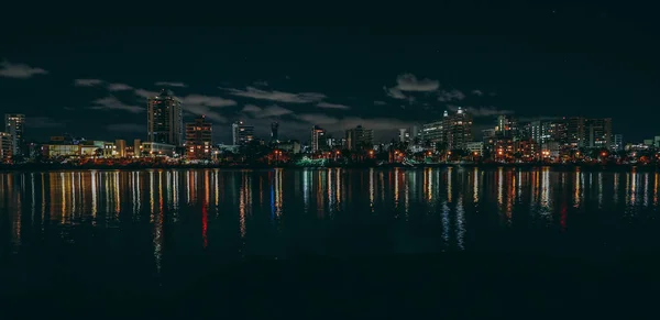 海岸高楼的全景 夜间在湖面上反射灯光 — 图库照片