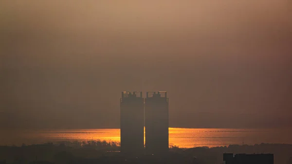Een Silhouet Van Twee Gebouwen Bij Zonsondergang Achtergrond Van Zee — Stockfoto