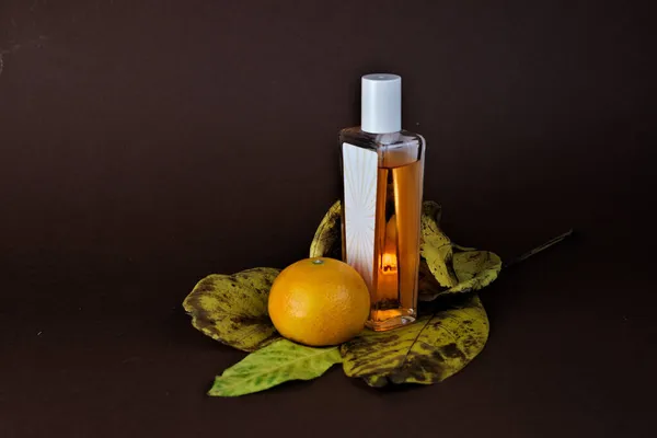 Eine Nahaufnahme Einer Duftflasche Einer Orange Und Blättern Auf Schwarzem — Stockfoto