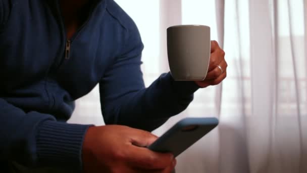 Mann Trinkt Kaffee Und Scrollt Telefon — Stockvideo