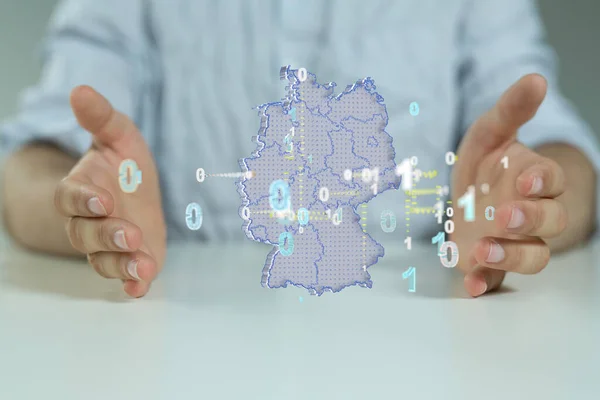 A 3D rendering of Germany map with binary codes floating in between human hands- network and global connection concept