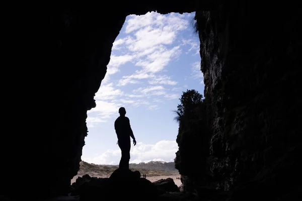 Una Silueta Hombre Pie Sobre Una Roca Entrada Una Cueva —  Fotos de Stock