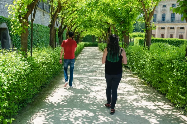 一个由两个人组成的特写镜头 男人和女人在公园的一条美丽的通道上散步 旁边是草 — 图库照片