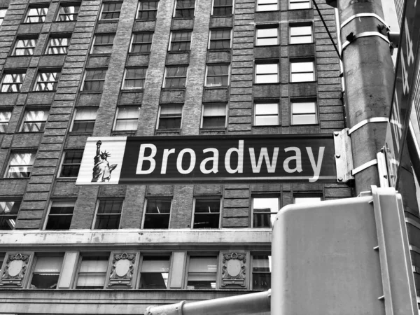 ニューヨークのブロードウェイへの方向と道路標識のグレースケールのローアングルショット — ストック写真
