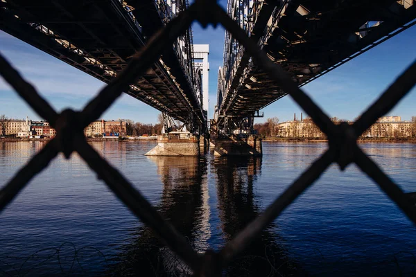 通过生锈的旋风栅栏在河上架桥的特写镜头 — 图库照片