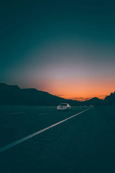 Автомобиль Проезжающий Асфальтированной Дороге Живописным Горизонтом Заката — стоковое фото