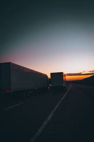 Dois Caminhões Dirigindo Através Uma Estrada Asfalto Com Horizonte Pôr — Fotografia de Stock