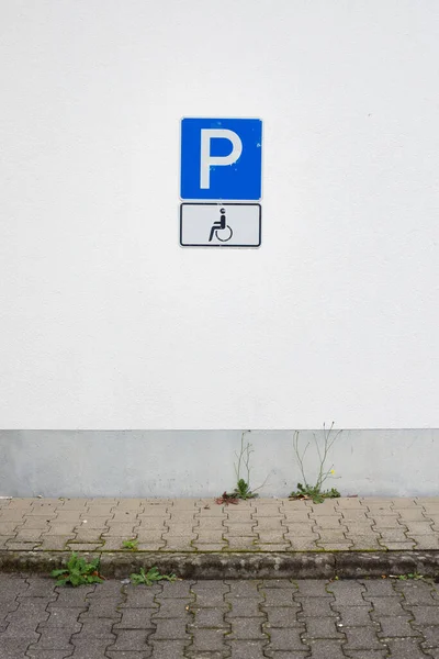 在室外的墙上垂直拍摄的停车场和轮椅路标 — 图库照片