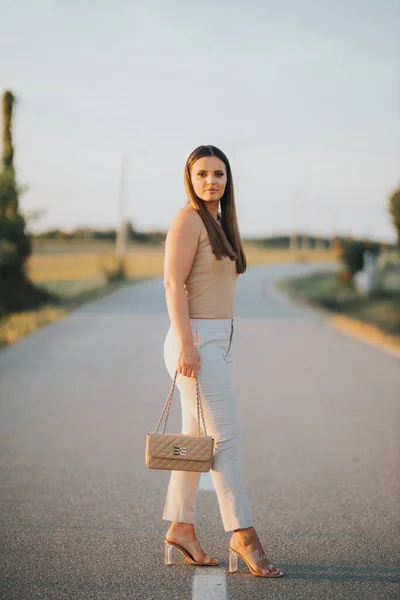 一个年轻的白人女性模特儿在路上摆姿势的垂直镜头 — 图库照片